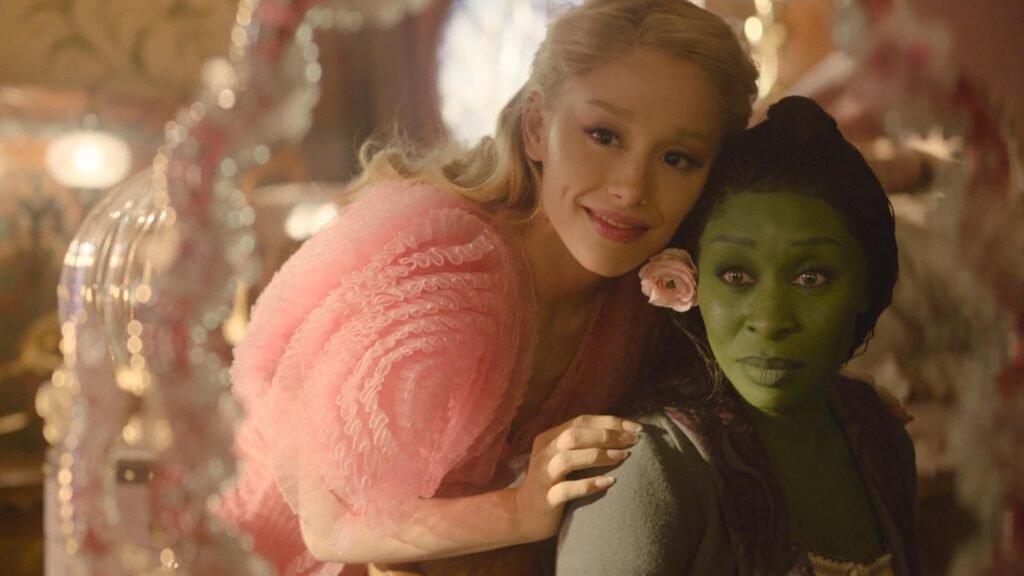 ariana grande as glinda smiling in a sparkling gown in the wicked movie trailer